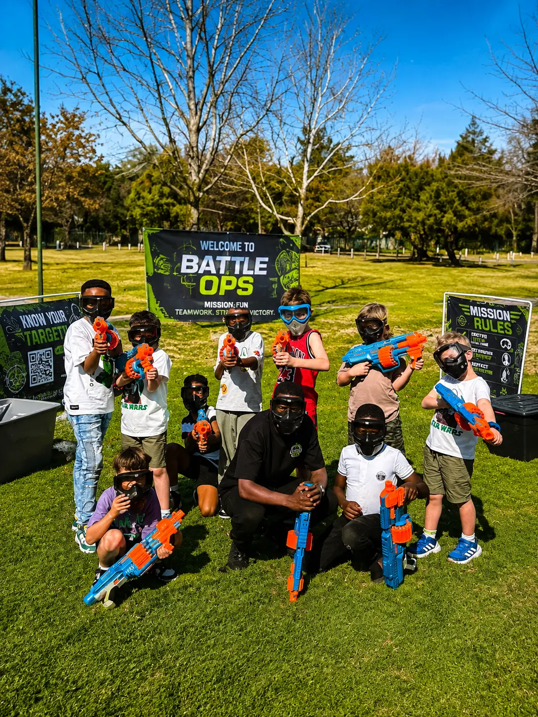 Battle Ops host with a group of kids in safety masks holding Nerf blasters at a mobile Nerf party